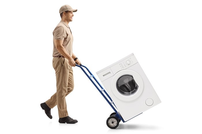 man hauling away a washing machine on a dolly